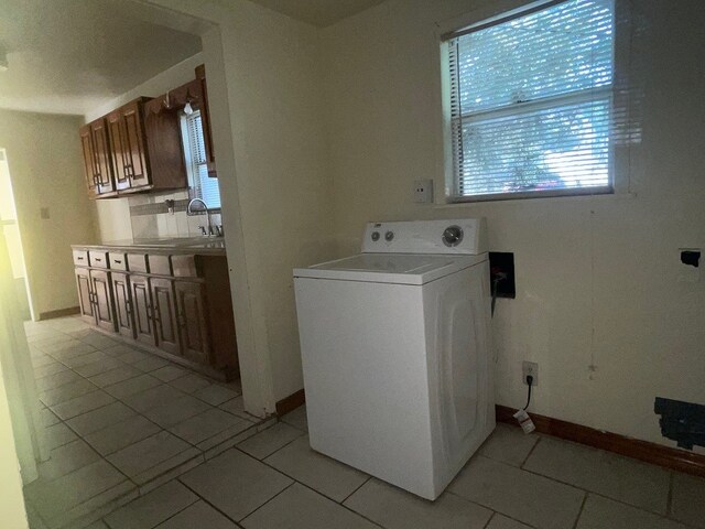 laundry room featuring light tile patterned flooring, sink, and washer / clothes dryer