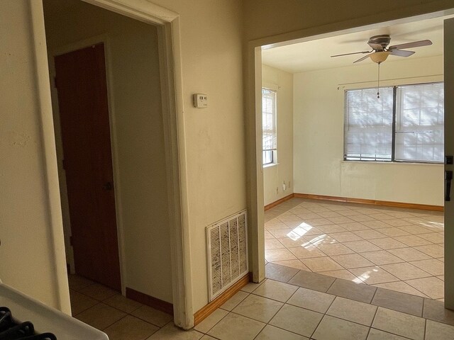 tiled spare room with ceiling fan