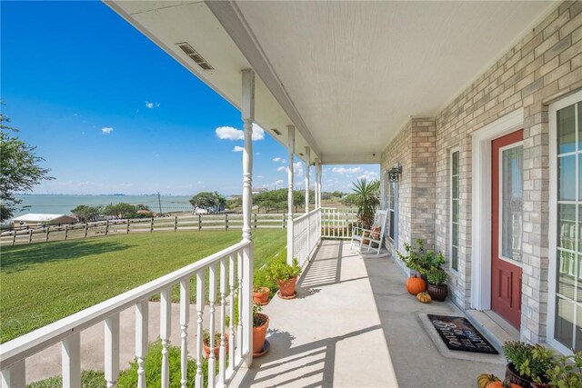 view of patio / terrace featuring covered porch and a water view