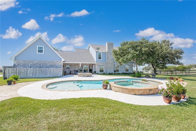 view of swimming pool featuring an in ground hot tub, a patio, and a lawn