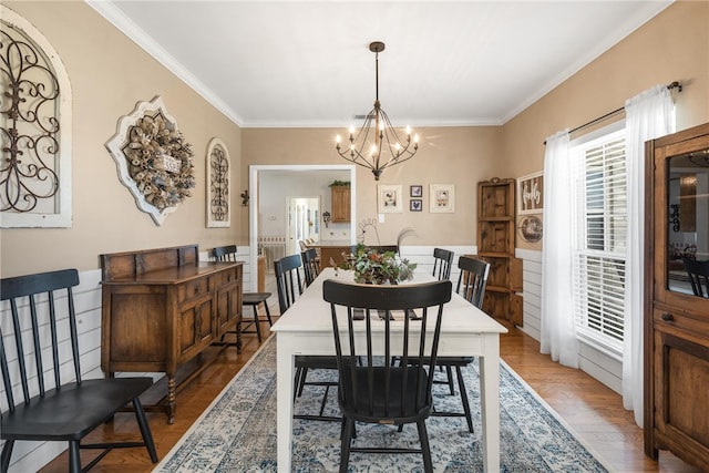 dining area featuring ornamental molding, a chandelier, and light wood-type flooring