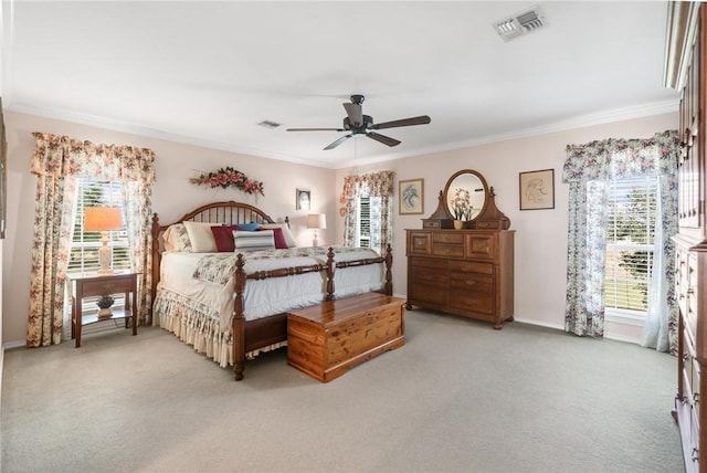 bedroom featuring ceiling fan, light colored carpet, ornamental molding, and multiple windows