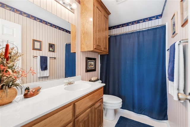 bathroom with tile patterned flooring, vanity, and toilet