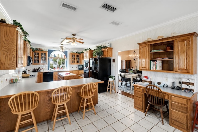 kitchen featuring a kitchen breakfast bar, kitchen peninsula, black appliances, and ornamental molding