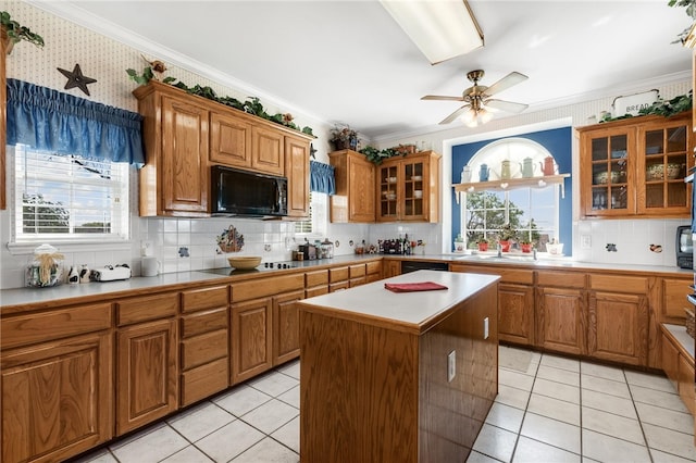 kitchen with a center island, tasteful backsplash, crown molding, light tile patterned floors, and black appliances