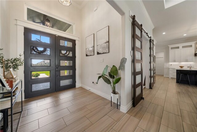 734 Buffalo Creek Dr, Corpus Christi, TX 78415 - foyer featuring a barn door, ornamental molding, recessed lighting, and wood tiled floors