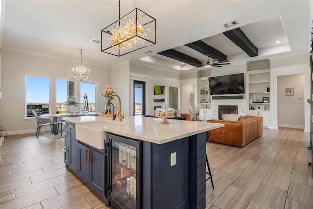 734 Buffalo Creek Dr, Corpus Christi, TX 78415 - kitchen with wine cooler, a chandelier, light countertops, ceiling fan, and a large fireplace