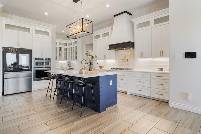 734 Buffalo Creek Dr, Corpus Christi, TX 78415 - kitchen featuring custom exhaust hood, stainless steel appliances, a breakfast bar, a center island with sink, and backsplash