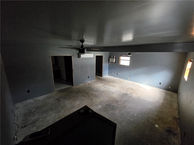 spare room with concrete flooring, a wall mounted air conditioner, and ceiling fan