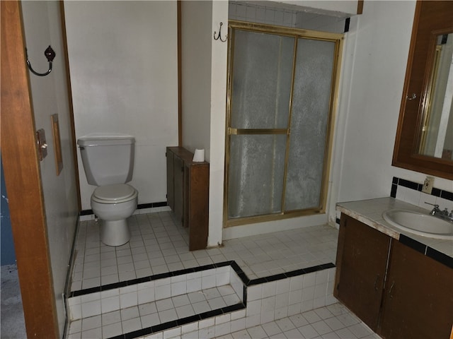 bathroom featuring toilet, tile patterned flooring, tasteful backsplash, an enclosed shower, and vanity