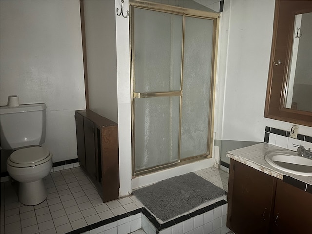 bathroom featuring tile patterned flooring, an enclosed shower, vanity, and toilet