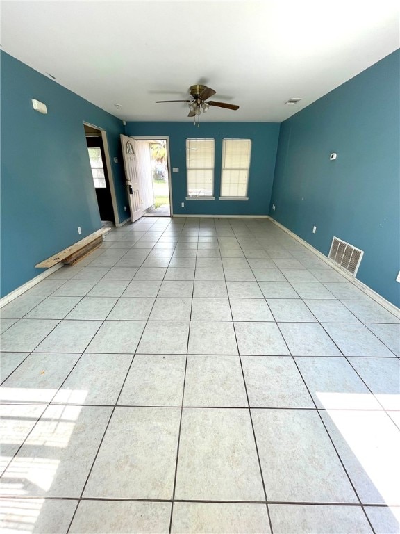 empty room with ceiling fan and light tile patterned floors