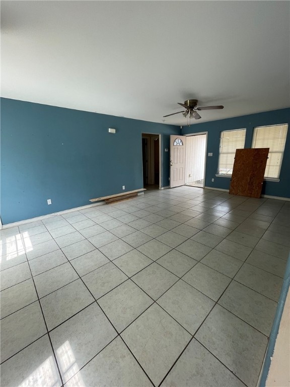 tiled spare room featuring ceiling fan