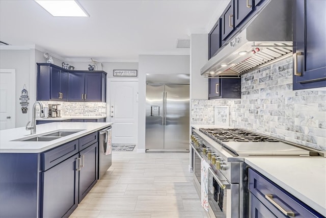 kitchen with blue cabinets, sink, high quality appliances, crown molding, and backsplash