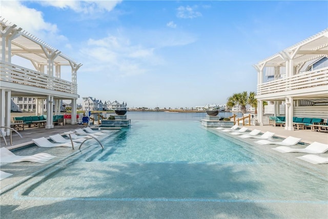 view of swimming pool with a patio, a water view, and a pergola