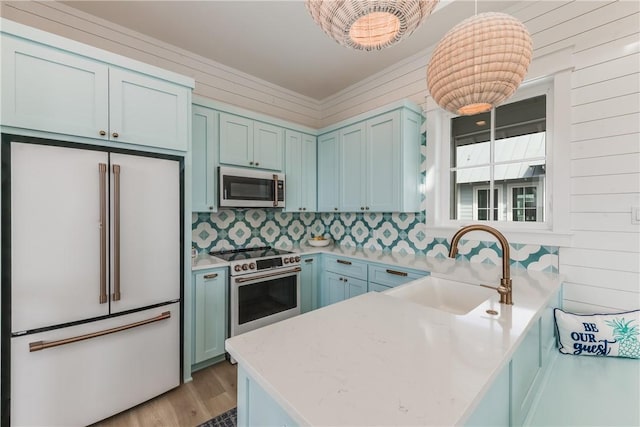 kitchen featuring pendant lighting, sink, white fridge, stainless steel range, and kitchen peninsula