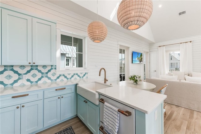 kitchen featuring a healthy amount of sunlight, decorative light fixtures, kitchen peninsula, and sink