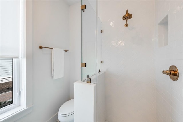 bathroom with toilet and a tile shower