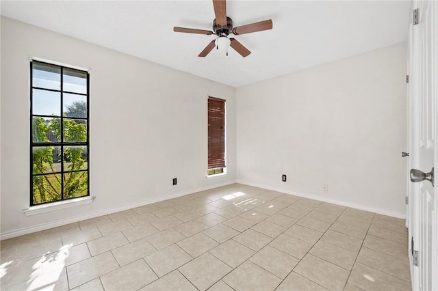 tiled spare room featuring ceiling fan and a healthy amount of sunlight