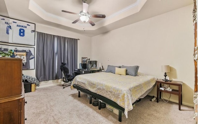 bedroom featuring a raised ceiling, ceiling fan, carpet floors, and crown molding