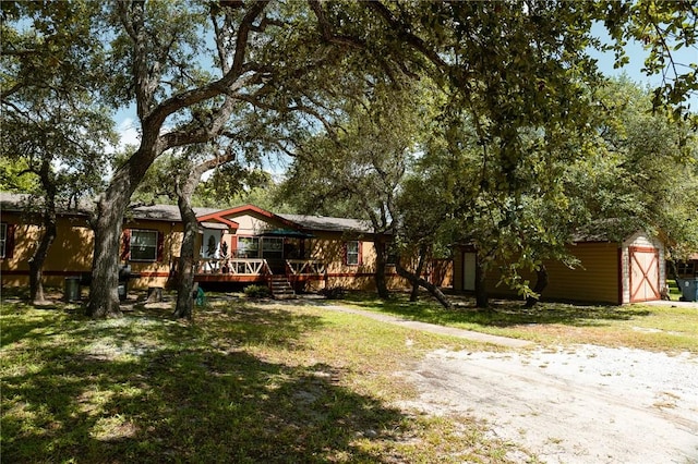 3081 Hackberry Ave, Ingleside, TX 78362 - view of front of property featuring a wooden deck, a garage, a front yard, a shed, and driveway