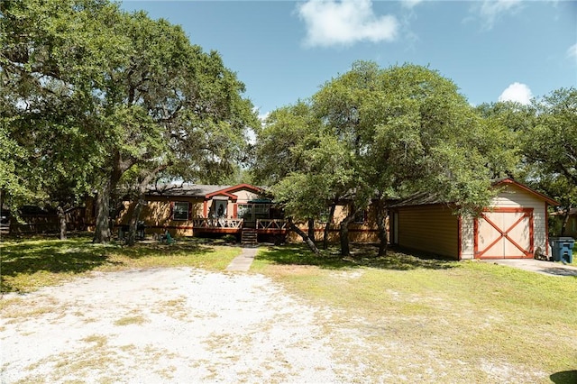 3081 Hackberry Ave, Ingleside, TX 78362 - view of front of property with a front lawn, a storage unit, a wooden deck, and a detached garage