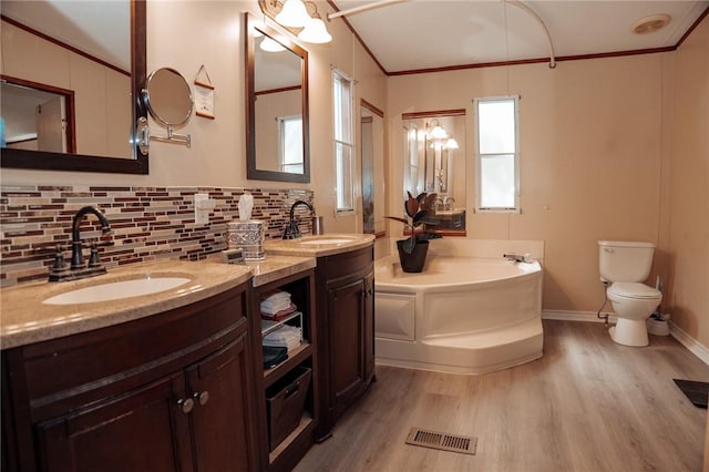 3081 Hackberry Ave, Ingleside, TX 78362 - full bath with a garden tub, wood finished floors, double vanity, tasteful backsplash, and crown molding