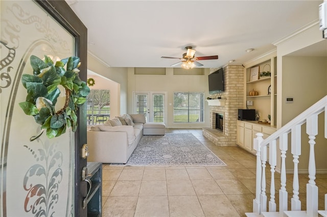 living room featuring a fireplace, built in features, light tile patterned flooring, and ceiling fan