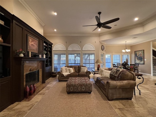 living room featuring a premium fireplace, ceiling fan with notable chandelier, and crown molding