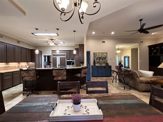 living room featuring ceiling fan with notable chandelier and crown molding