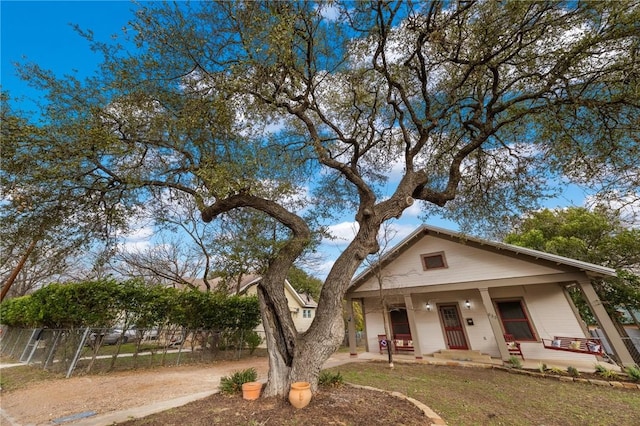 view of front of house with covered porch and fence