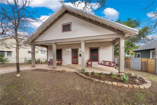 view of front of property featuring covered porch and fence