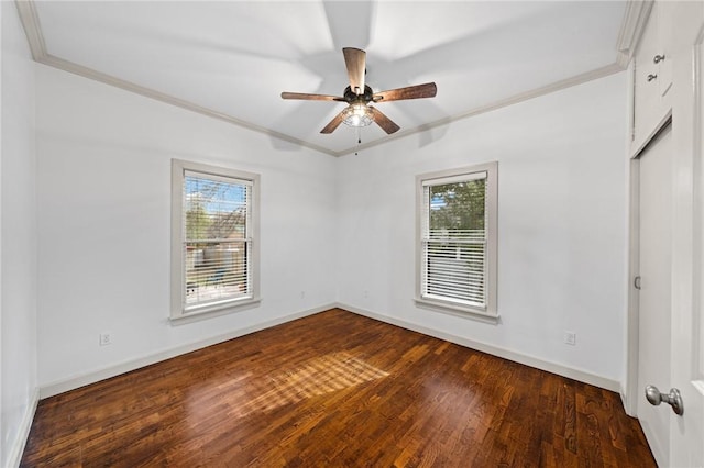 empty room featuring a wealth of natural light, dark wood-style floors, and crown molding