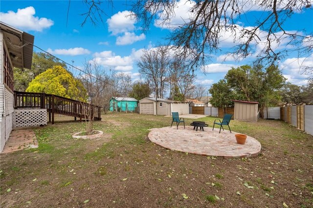view of yard featuring an outdoor structure, a fenced backyard, a shed, and an outdoor fire pit