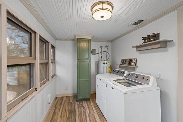 laundry room with visible vents, electric water heater, light wood finished floors, laundry area, and washing machine and clothes dryer