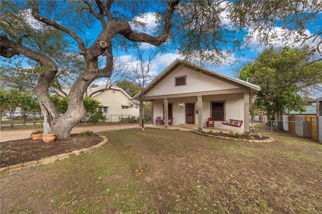bungalow-style home featuring a patio area, a front lawn, and fence
