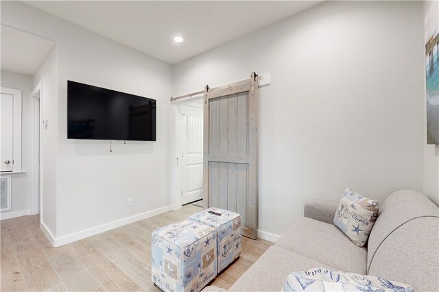 living room featuring a barn door and light hardwood / wood-style floors