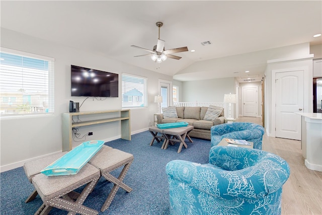 living room featuring ceiling fan, light hardwood / wood-style flooring, and vaulted ceiling