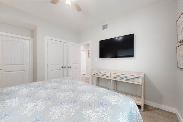 bedroom featuring light hardwood / wood-style floors, ceiling fan, and a closet