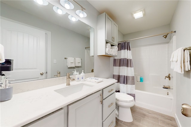 full bathroom with hardwood / wood-style floors, shower / bath combo with shower curtain, vanity, and toilet