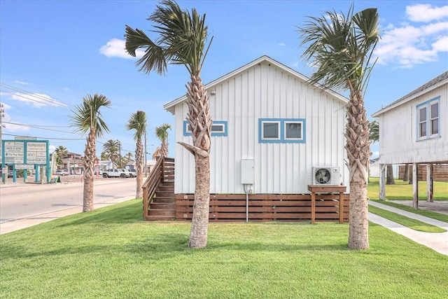 view of front of home featuring ac unit and a front lawn