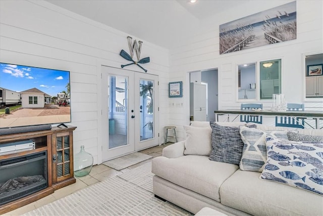 67 Augusta Cir, Aransas Pass, TX 78336 - living room featuring french doors, tile patterned flooring, and wooden walls