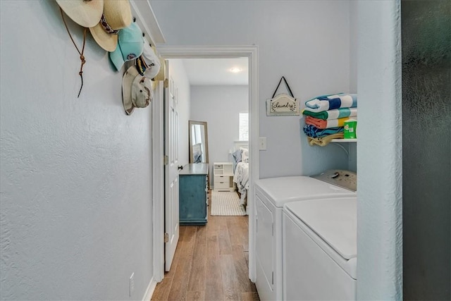 67 Augusta Cir, Aransas Pass, TX 78336 - washroom featuring washing machine and clothes dryer, light wood-type flooring, and a textured wall