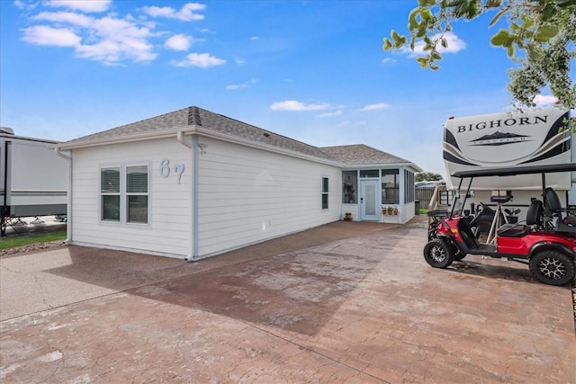 67 Augusta Cir, Aransas Pass, TX 78336 - view of home's exterior with a sunroom, a shingled roof, and driveway