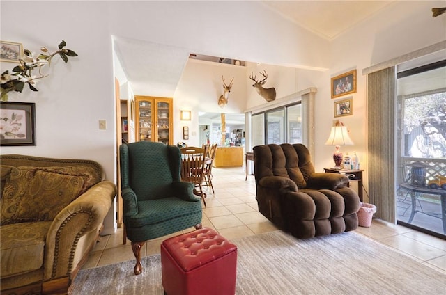 living area featuring lofted ceiling, light tile patterned floors, and a wealth of natural light