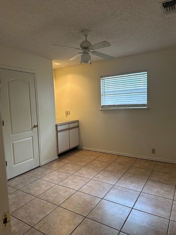 402 Myrtle St, Fulton, TX 78358 - empty room with ceiling fan, light tile patterned flooring, and a textured ceiling
