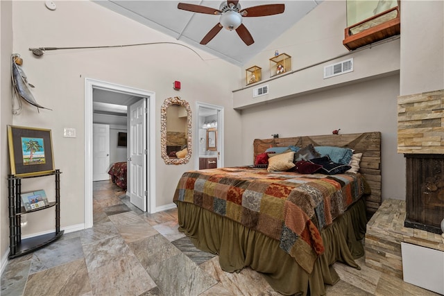 bedroom with a multi sided fireplace, ceiling fan, connected bathroom, and lofted ceiling