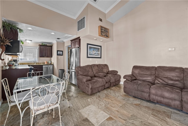 living room with a towering ceiling and crown molding