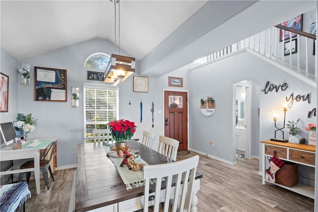 dining area featuring vaulted ceiling and light wood-type flooring