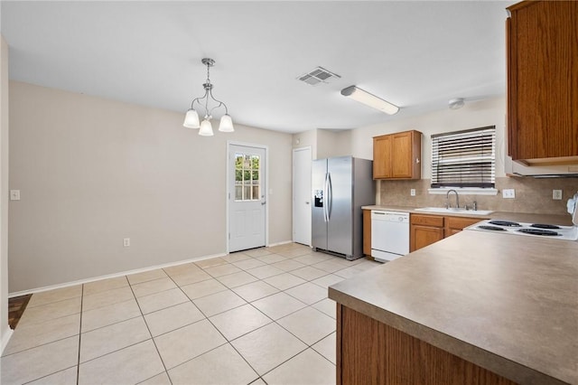 1522 W Nelson Ave, Aransas Pass, TX 78336 - kitchen featuring white appliances, a sink, decorative backsplash, light tile patterned floors, and decorative light fixtures